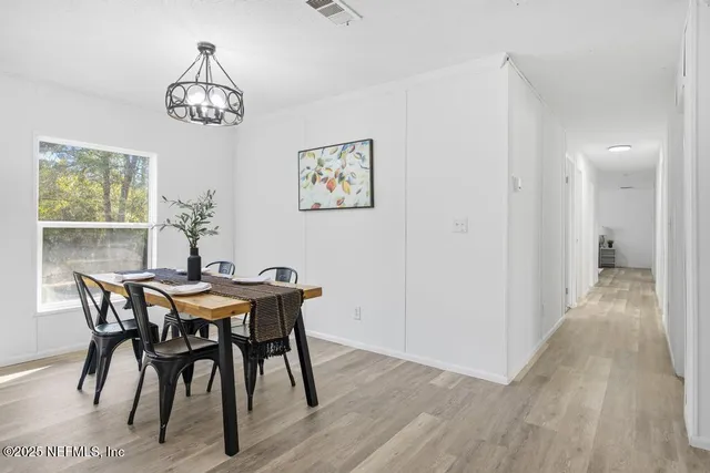 a view of a dining room with furniture and chandelier