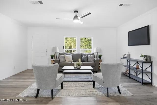 a living room with furniture a flat screen tv and a window