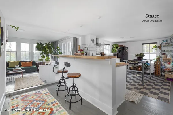 a living room with furniture and a dining table with kitchen view