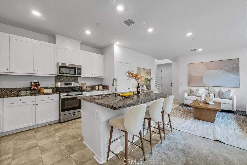 5584 Kate Way, Unit 10 Fontana, CA 92335 - Photo 5 of 42 a kitchen with white cabinets and stainless steel appliances