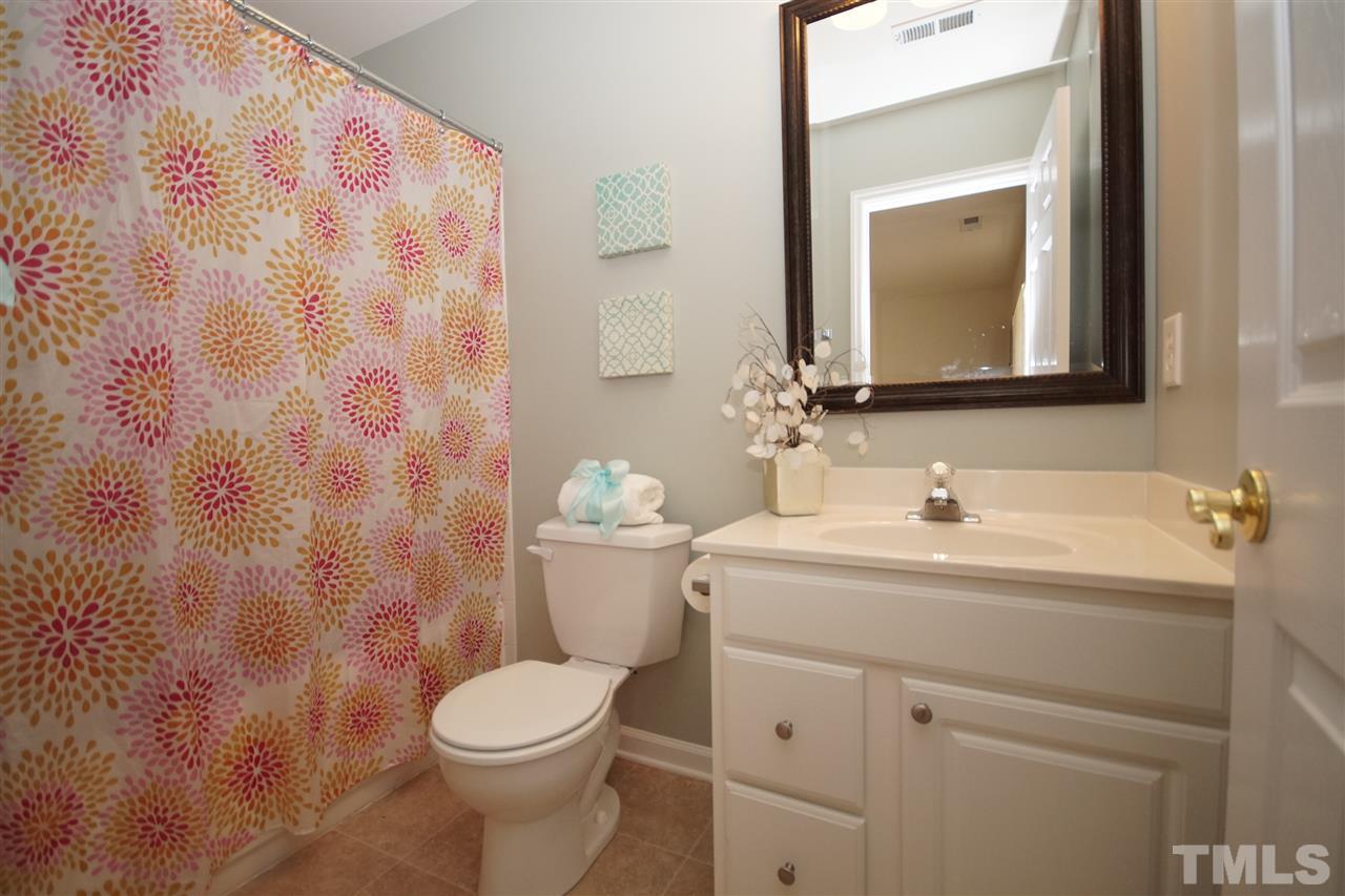 5202 Echo Ridge Road Raleigh, NC 27612 - Photo 5 of 22 a bathroom with a toilet sink vanity and mirror