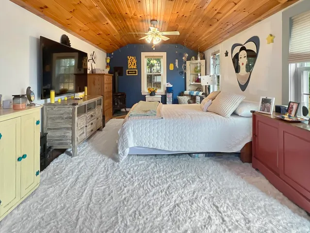 a living room with furniture a flat screen tv and a large window