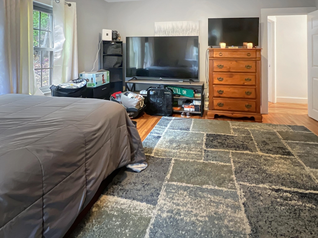 1649 Washington Street Canton, MA 02021 - Photo 32 of 38 a bedroom with a bed and a flat tv screen