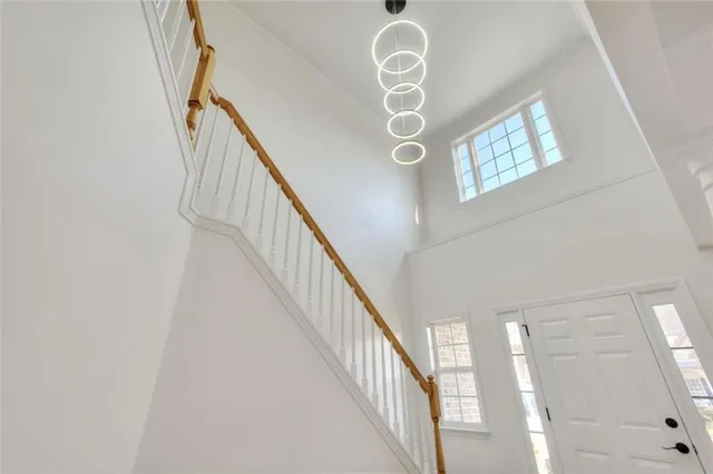 a large kitchen with stainless steel appliances a large counter top a sink a refrigerator and white cabinets