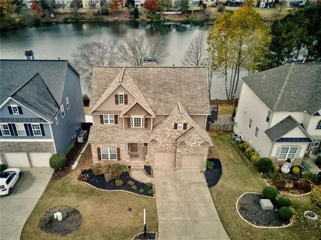 an aerial view of residential houses with outdoor space and trees all around