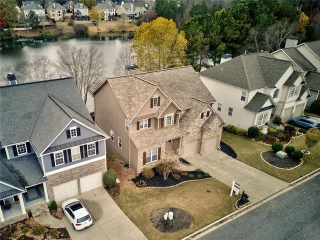 an aerial view of residential houses with outdoor space and parking