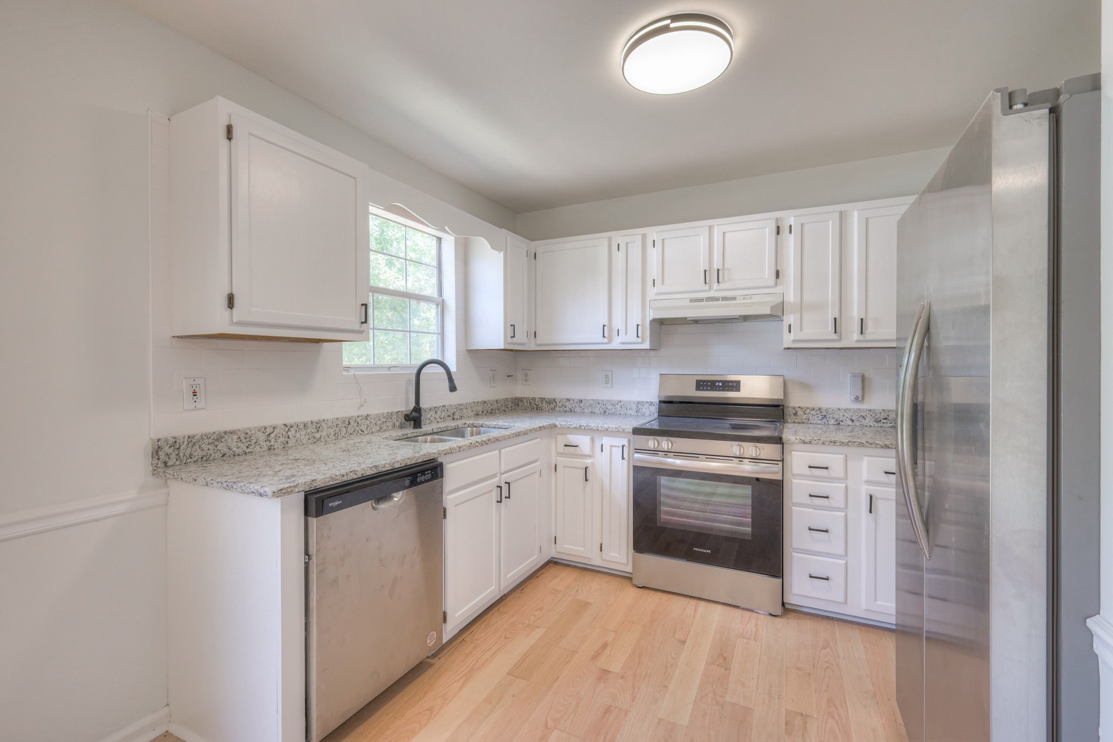 7195 Chester Road Fairview, TN 37062 - Photo 18 of 32 a kitchen with granite countertop white cabinets sink and stainless steel appliances