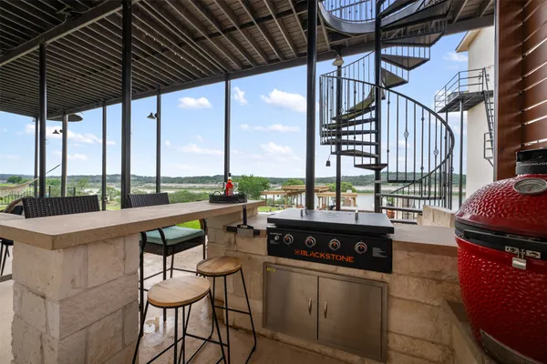 a living room with furniture kitchen view and a large window