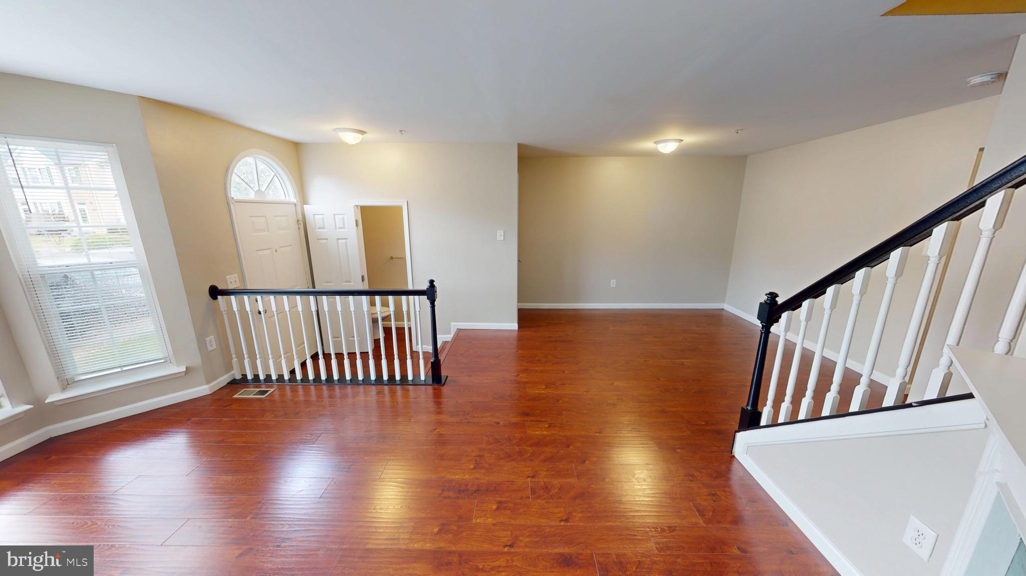 10611 Riva Place White Plains, MD 20695 - Photo 12 of 93 a view of a hallway with wooden floor and windows