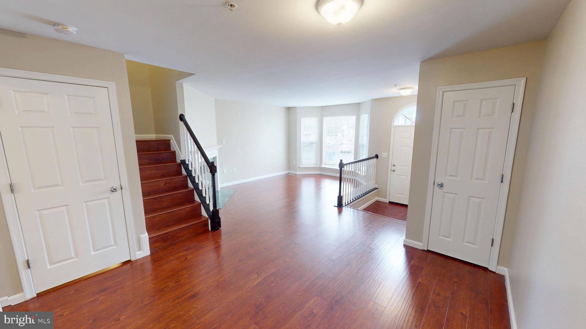 10611 Riva Place White Plains, MD 20695 - Photo 20 of 93 a view of an empty room with wooden floor and stairs