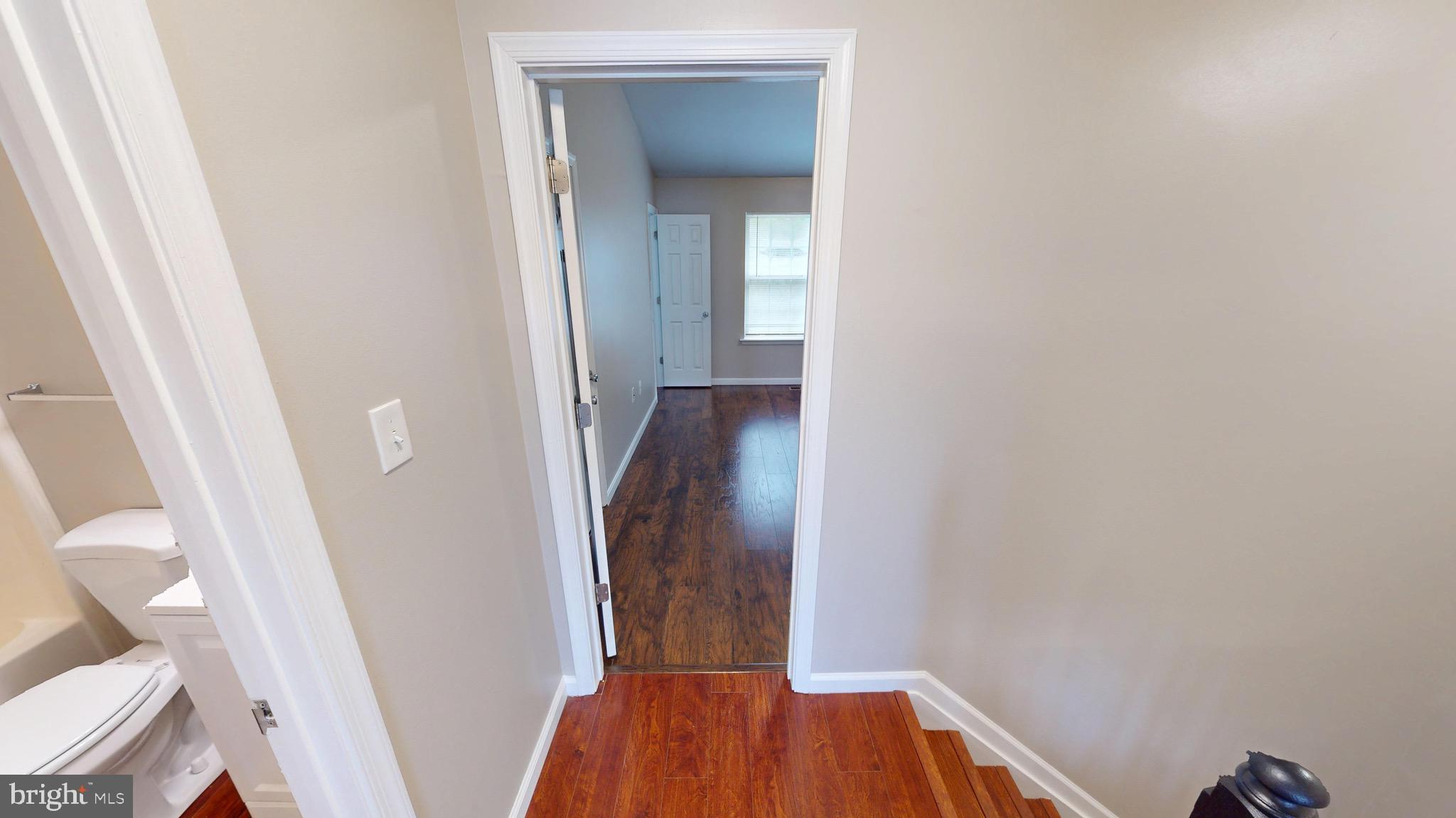 10611 Riva Place White Plains, MD 20695 - Photo 33 of 93 a view of a hallway with wooden floor and a bathroom