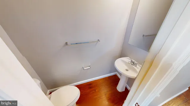 a view of a hallway with wooden floor and windows