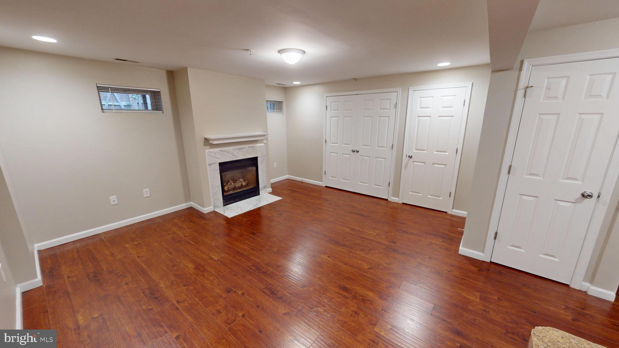 10611 Riva Place White Plains, MD 20695 - Photo 65 of 93 an empty room with wooden floor fireplace and windows