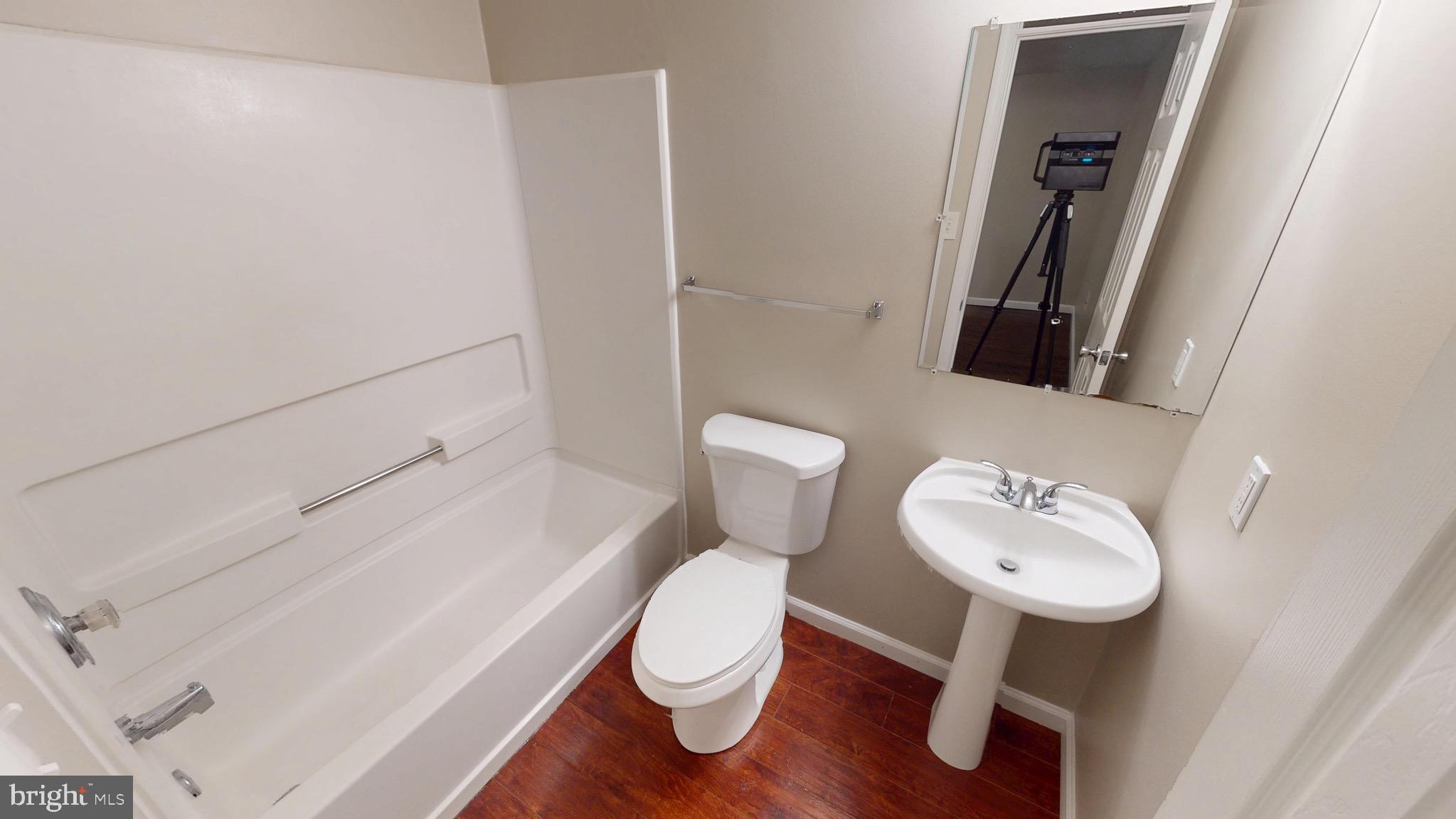 10611 Riva Place White Plains, MD 20695 - Photo 80 of 93 a white toilet sitting next to a bathroom sink and a mirror