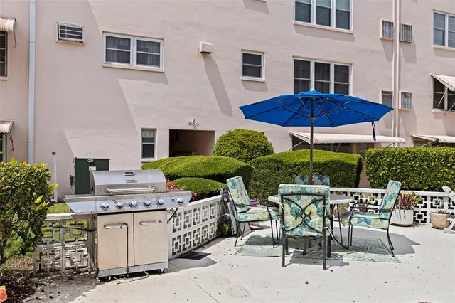 a view of an chairs and table under an umbrella
