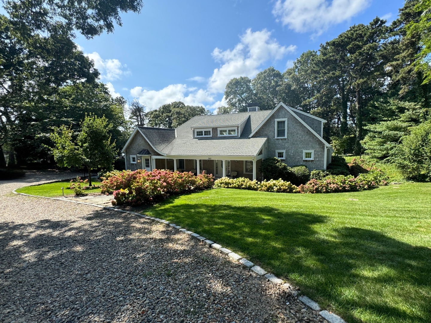 a view of a house with a big yard and potted plants