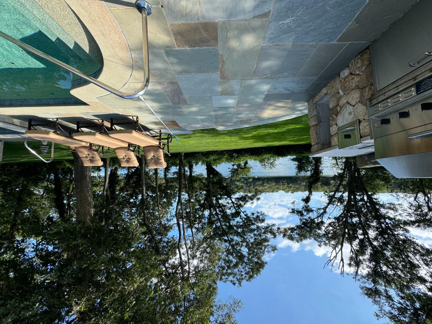 385 Barnes Road Oak Bluffs, MA 02557 - Photo 55 of 60 a view of a swimming pool with lawn chairs under an umbrella