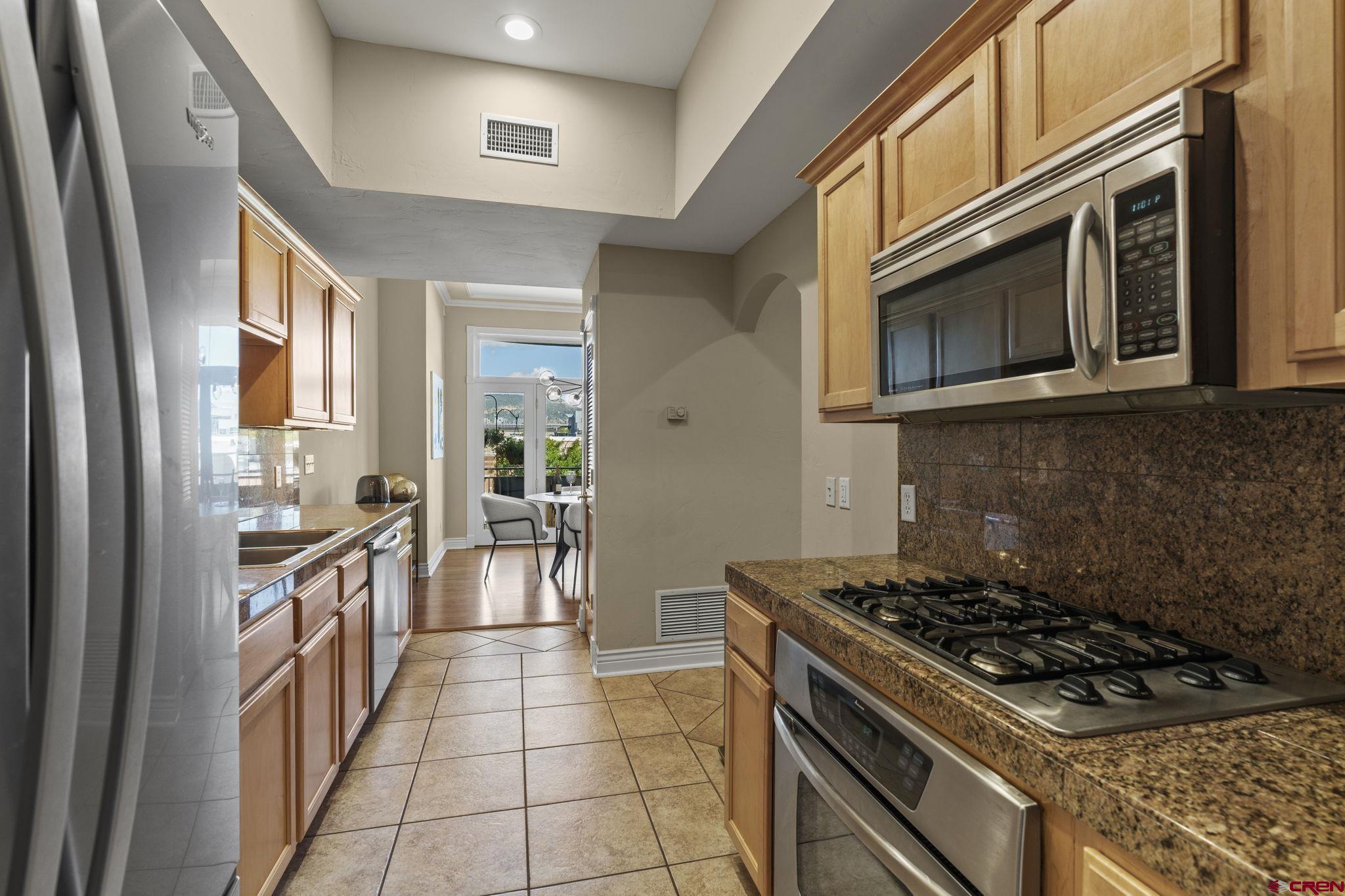543 East 2nd Avenue, Unit 3E Durango, CO 81301 - Photo 11 of 39 a kitchen with stainless steel appliances granite countertop a stove and a microwave