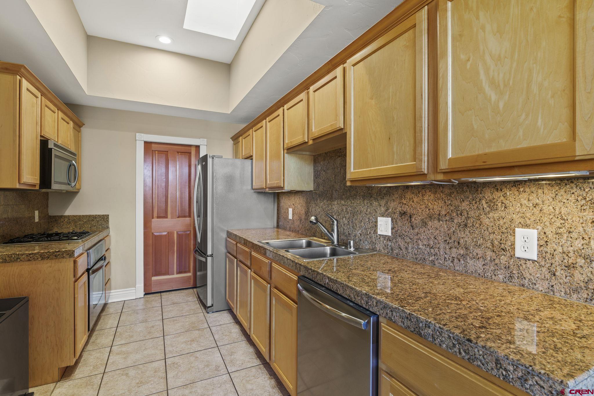 543 East 2nd Avenue, Unit 3E Durango, CO 81301 - Photo 8 of 39 a kitchen with stainless steel appliances granite countertop a sink stove and refrigerator