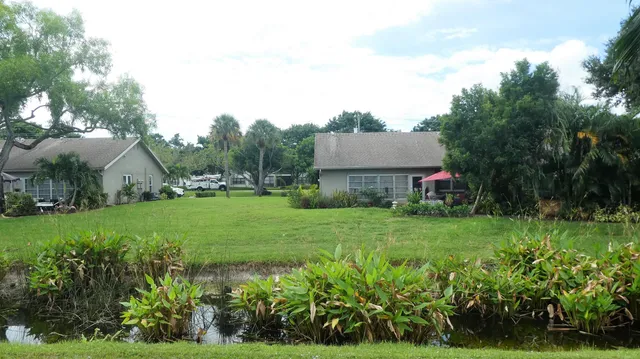 a view of a house with garden and a bench