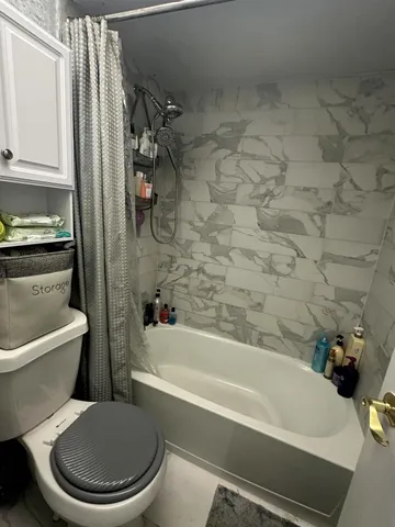 a white toilet and tub sitting next to a bathroom sink