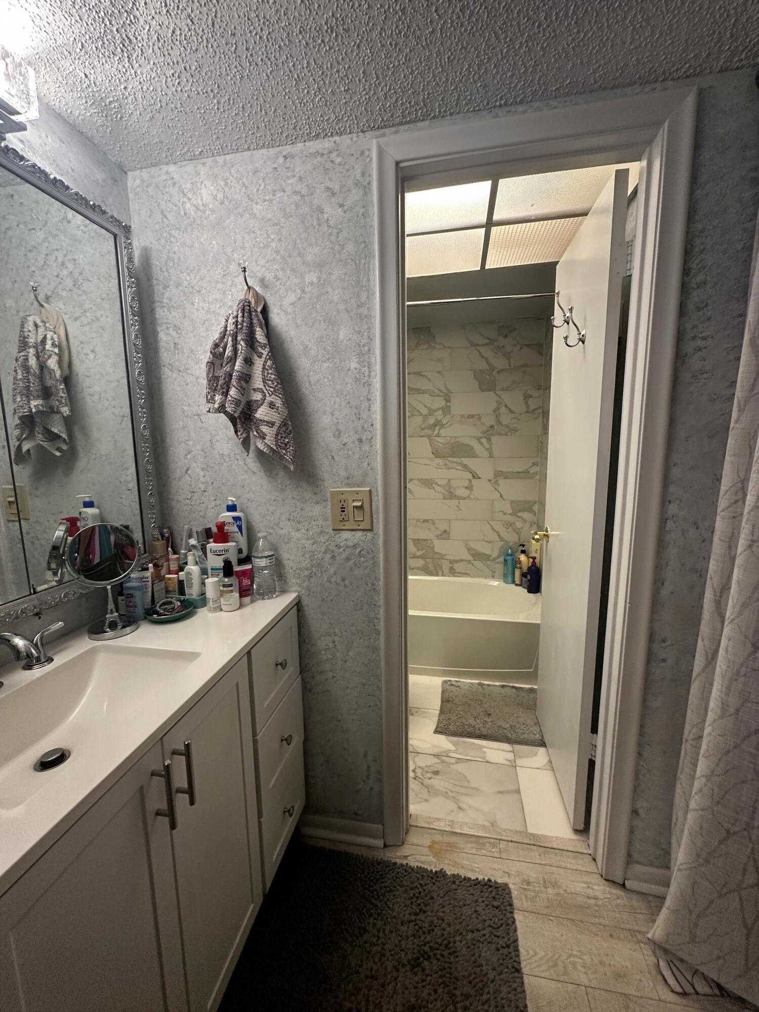 2500 Fiore Way, Unit 102C Delray Beach, FL 33445 - Photo 21 of 33 a bathroom with a sink and a mirror