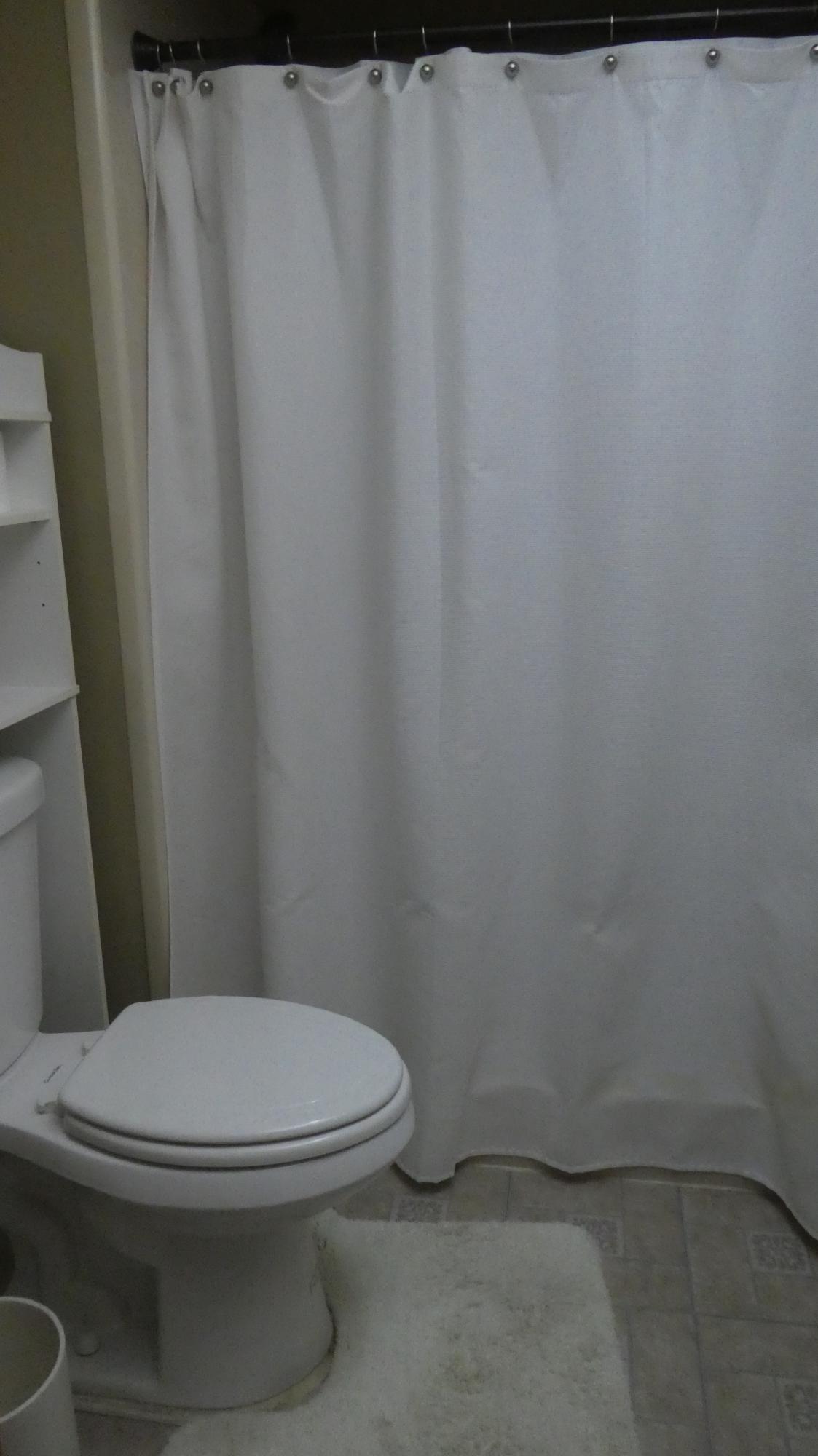 2500 Fiore Way, Unit 102C Delray Beach, FL 33445 - Photo 24 of 33 a white toilet sitting next to a shower curtain