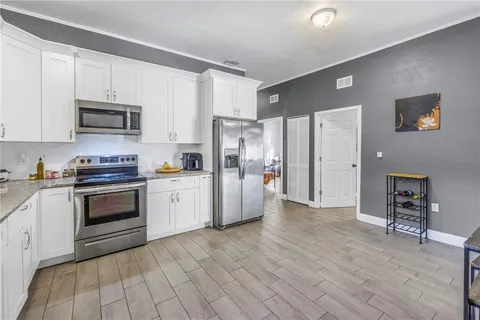 a kitchen with stainless steel appliances a refrigerator sink and cabinets
