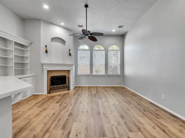 a view of empty room with wooden floor fireplace and a window