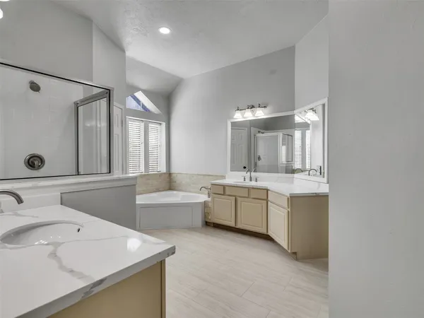 a bathroom with a double vanity sink mirror and bathtub