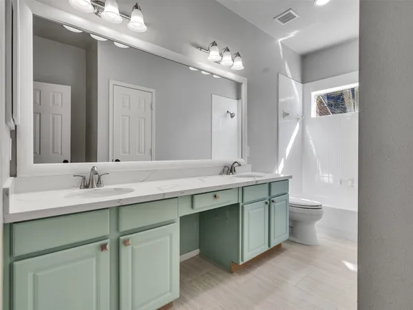 a bathroom with a double vanity sink and a mirror