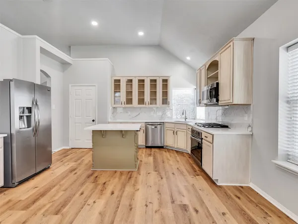 a kitchen with a refrigerator sink and cabinets