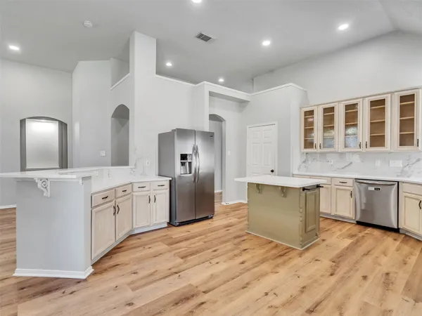 a kitchen with granite countertop a refrigerator stove top oven and sink