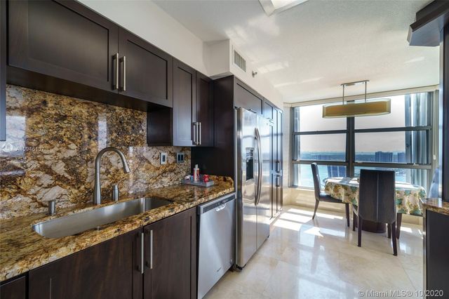 a kitchen with stainless steel appliances granite countertop a refrigerator and a stove