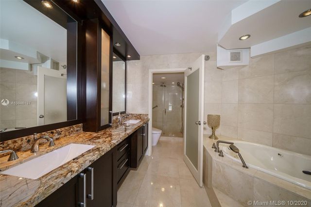 a bathroom with a granite countertop sink a toilet and shower