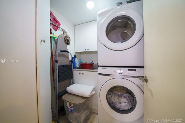 a bedroom with a large bed and a flat tv screen on dresser