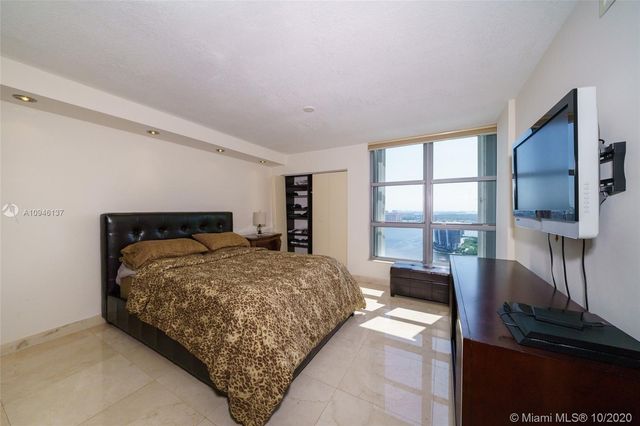 a bathroom with a granite countertop sink a toilet a mirror and shower