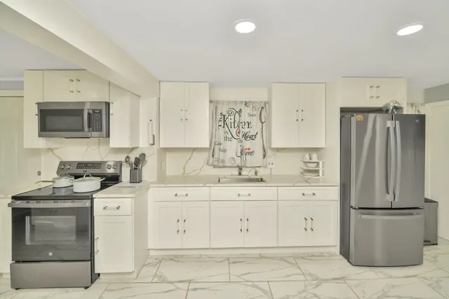 a kitchen with a refrigerator sink and cabinets