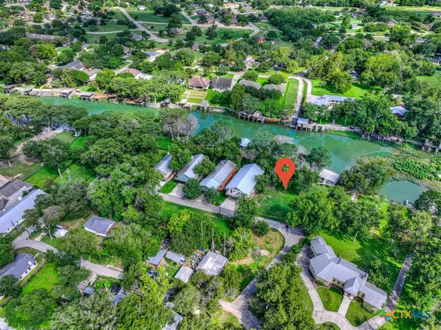 an aerial view of residential house with outdoor space and trees all around