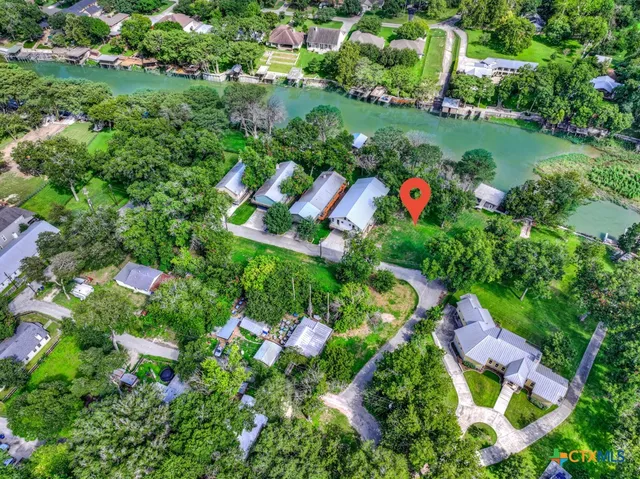 an aerial view of residential house with outdoor space and trees all around