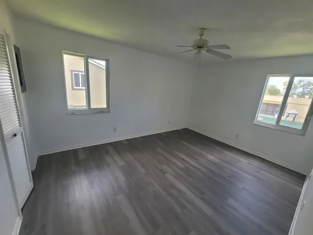 an empty room with wooden floor and a window