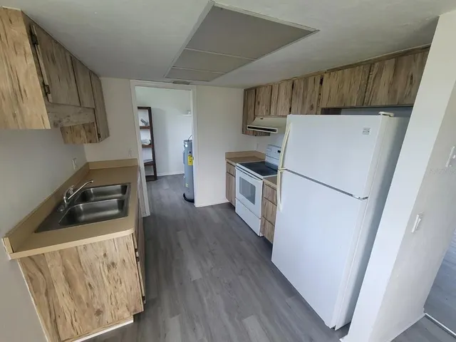 a kitchen with a refrigerator sink stove and cabinets