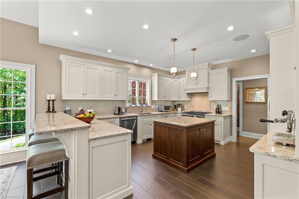 11555 Double Spring Road Lewisville, NC 27023 - Photo 12 of 50 Thoughtfully renovated kitchen with quartz countertops, custom cabinets, bar seating, and pendant lighting