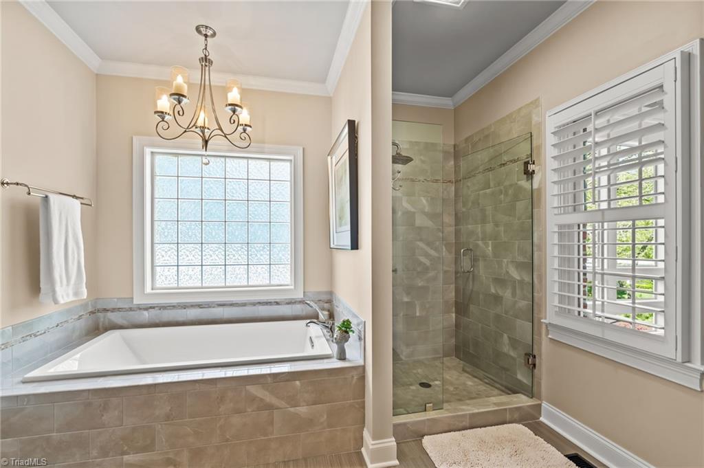 11555 Double Spring Road Lewisville, NC 27023 - Photo 20 of 50 Soaking tub and walk in tiled shower with glass block window and plantation shutters for privacy