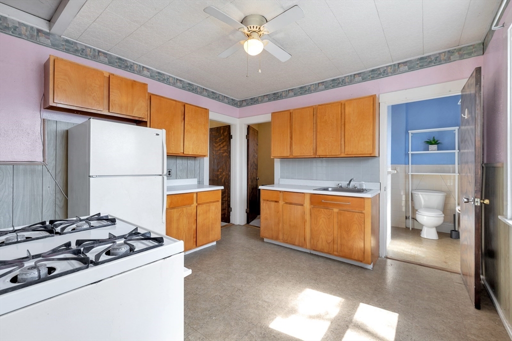 151-153 Forest Street Arlington, MA 02474 - Photo 5 of 20 a kitchen with a stove a refrigerator and a stove top oven