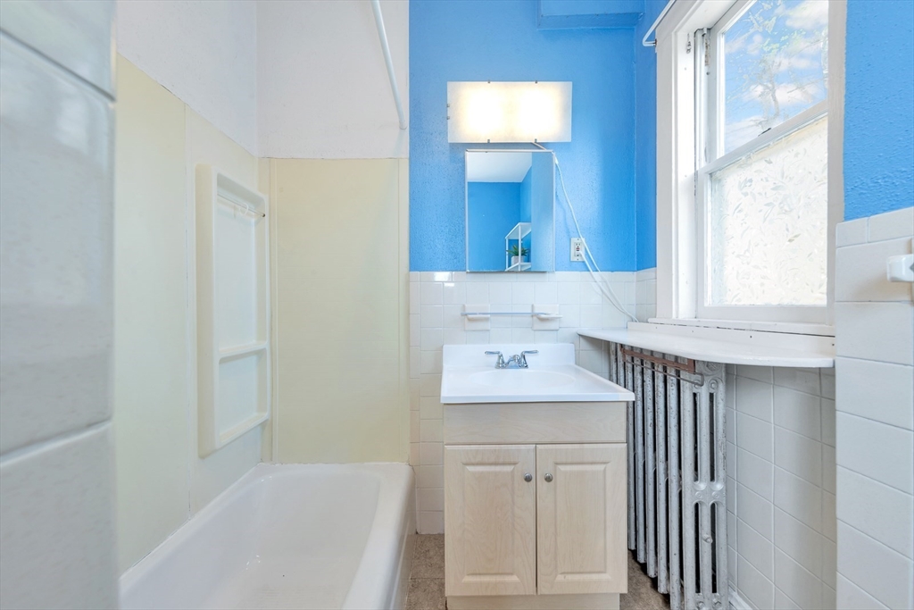 151-153 Forest Street Arlington, MA 02474 - Photo 10 of 20 a bathroom with a sink a mirror and a window