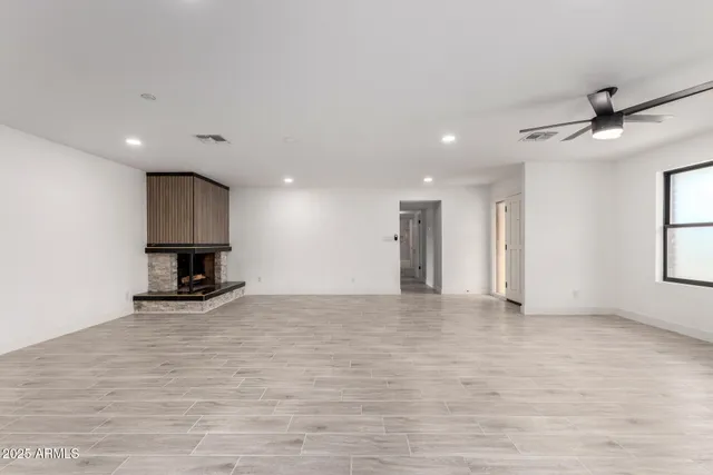 a view of empty room with wooden floor and fireplace