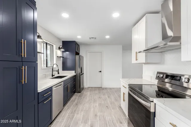 a kitchen with stainless steel appliances granite countertop a sink a stove and a refrigerator