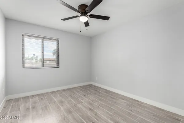 an empty room with a window and a ceiling fan