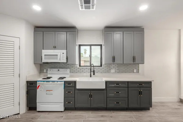 a view with cabinets a sink and a mirror